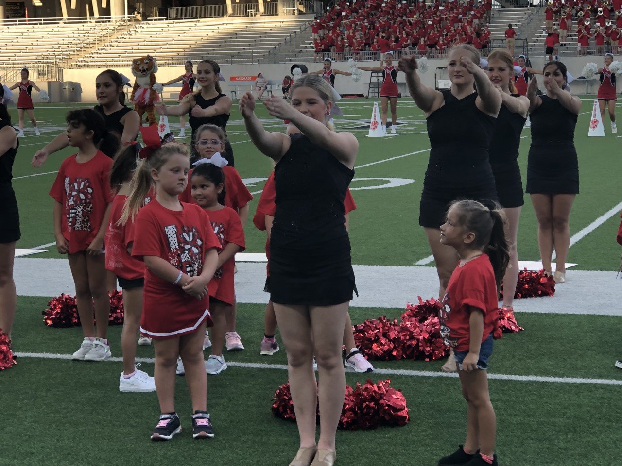 Katy Bengal Brigade vice president Madeline Ritz performs while two future Brigade members look on.